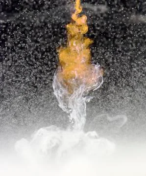 White unknown liquid drops into clear water creating a mix of liquid and oils Stock Photos