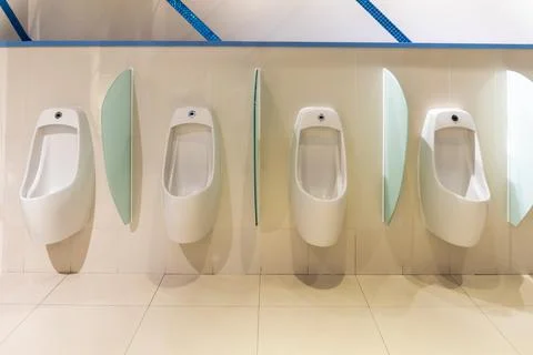 White urinal with a row of automatic pouring sensors and a stopper Foto stock