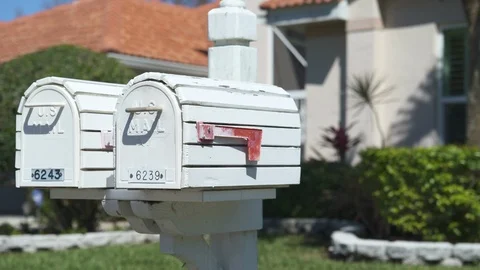 White US mailbox with a red flag in a suburban neighborhood - Florida Video stock 91272399