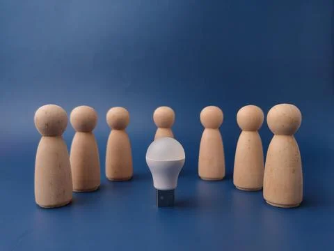 White USB LED light bulb standing in front of a semi-circle of wooden peg d.. Фото