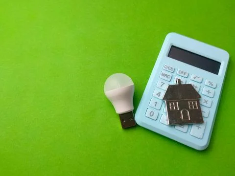 White USB LED light bulb placed next to a light blue calculator with a silv.. 库存照片