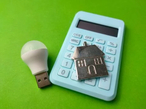 White USB LED light bulb placed next to a light blue calculator with a silv.. Stock-Fotos