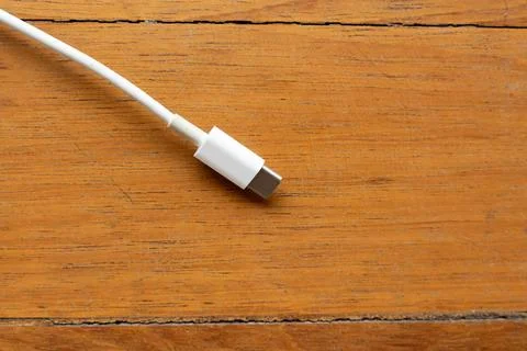 White USB Type-C Cable on Wooden Floor with Ample Copy Space Stock Photos