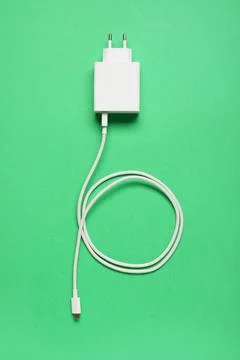 White USB type-c charger and cable for modern electronic devices on green bac Stock Photos