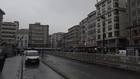 White Van Drives Beside Tram Line on Wet Istanbul Street Lined with Bank Signs Stock Footage 346324982
