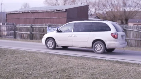 White Van Drives Down Small Paved Road By Fence Video stock 87883974