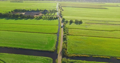 A white van drives towards a drone while it flies backwards on a small road Video stock 63614995