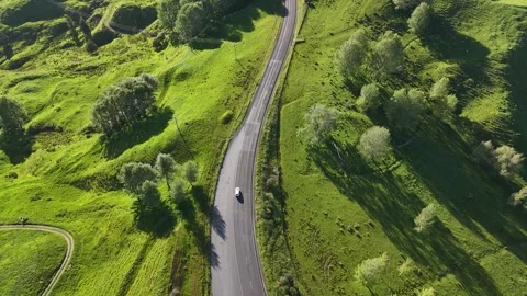 White van driving between green country side in New Zealand on a suny day. Stock Footage 269344712