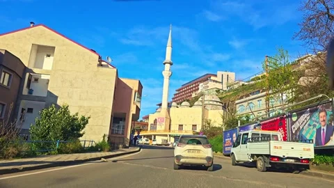 A white van driving down a street next to a tall building Stock Footage 273004195