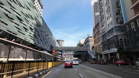 A white van is driving down a street in front of a hotel Stock-Footage 317308138