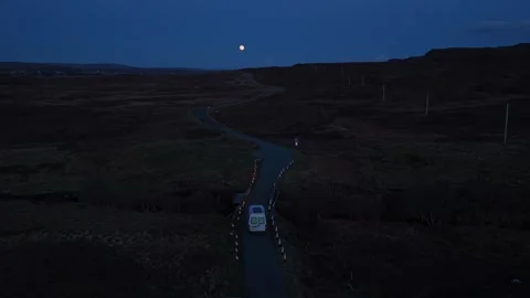 White van driving on winding isle of skye road under a full moon 库存影片 334059601
