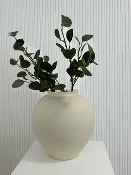 White vase with eucalyptus branches on the table Stock Photos