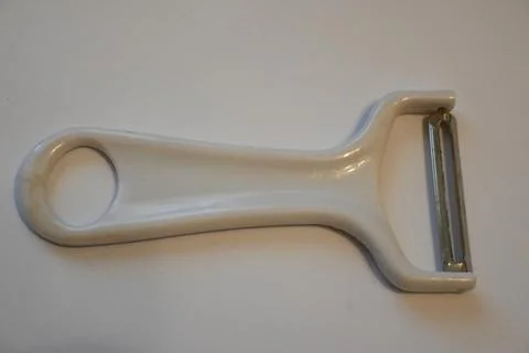 White vegetable peeler on a plain surface 스톡 사진