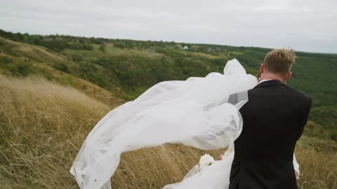 A white veil blowing in the wind. Couple standing in the canyon. Slow motion Stock Footage 202282156