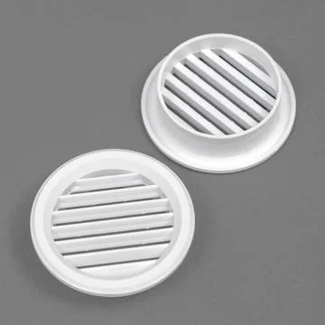 White ventilation grate on a gray background. Round shape. An element of the  Stock Photos