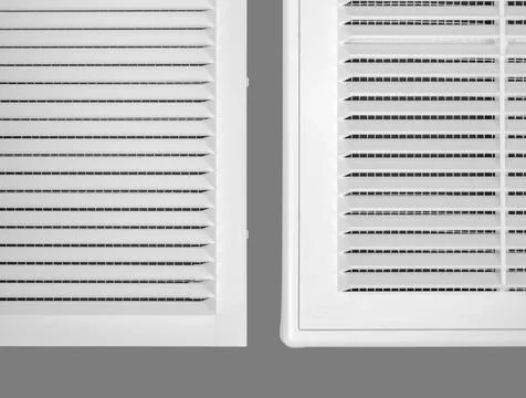 White ventilation grate on a gray background. Close-up. Material is plastic. Stock Photos