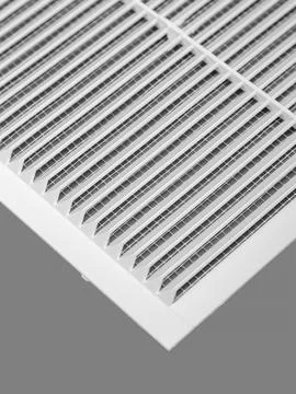 White ventilation grate on a gray background. Close-up. Material is plastic. Stock Photos