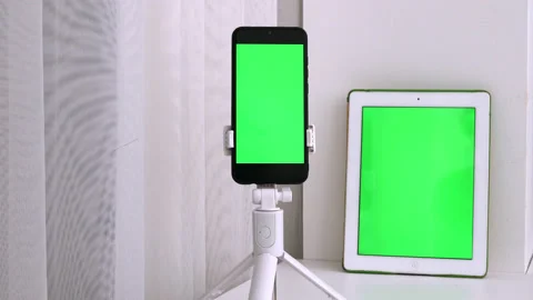 White vertical tablet and black smartphone device with green screen Stock Footage 219792521