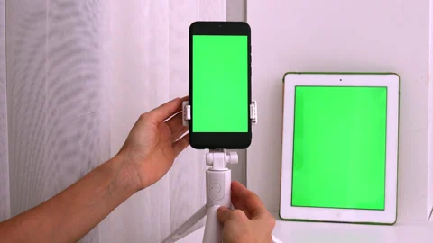 White vertical tablet and black smartphone device with green screen Stock Footage 219792617