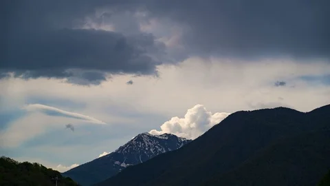 White very thick clouds spinning rise above the top of the mountain. Stock Footage 111690672