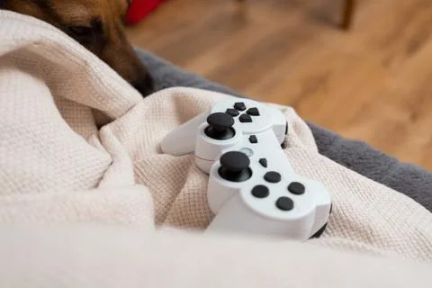 White video console controller laying down on a beige blanket, cosy vibes, sa Stock Photos