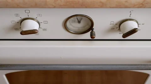 White Vintage Oven Control Panel with Brass Knobs and Central Clock Stock Footage 339069517