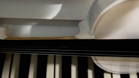 A white violin with a bow lies on a white piano Stock Footage 229690562