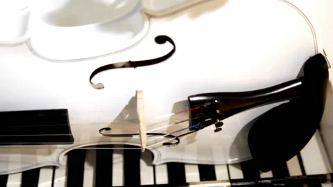 A white violin with a bow lies on a white piano 库存影片 229690667