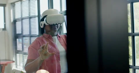 White VR headset user is controlling interface near windows with pinch, point as Stock Footage 341241238