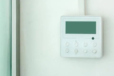 White wall air conditioning control panel with screen and control buttons. Stock Photos