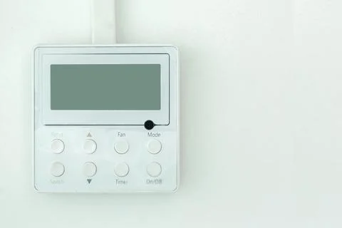 White wall air conditioning control panel with screen and control buttons. Stock Photos