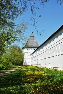 White wall and corner tower of the old monastery. Stock Photos