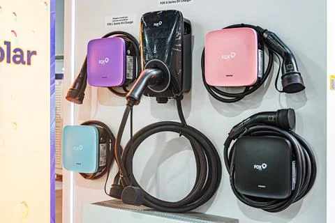 White wall backdrop displaying four functional electric vehicle EV chargers.. 写真素材