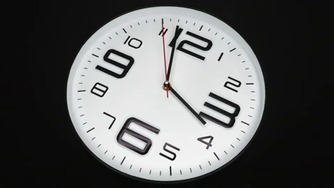 A White Wall Clock On Black Background With A Time Of 4.00 Am Or Pm. A Black Han Stock-Footage 221895798