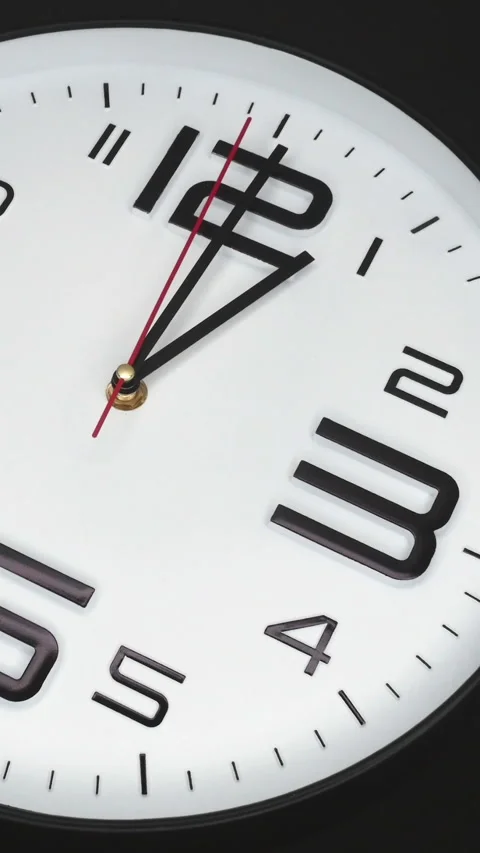 A White Wall Clock On Black Background With A Time Of 1.00 Am Or Pm. A Black Han Stock Footage 266739421