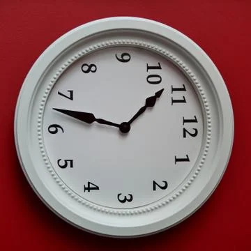 White wall clock on a red wall Stock Photos