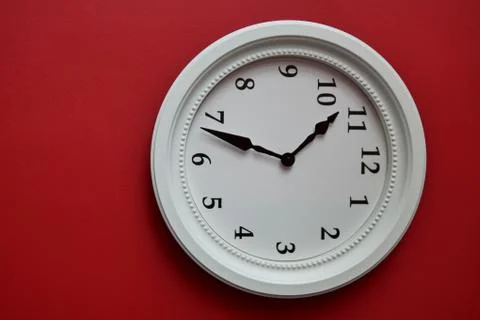 White wall clock on a red wall Stock Photos