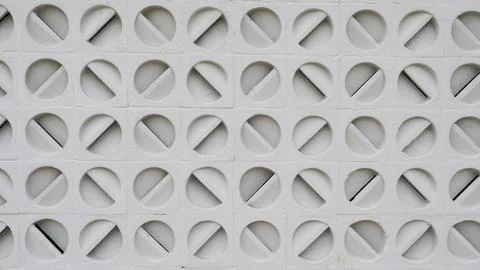 White wall with evenly spaced circular holes, geomteric pattern backgrounds Stock Photos