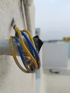 White Wall Fixed Small Plastic Pipe and Remaining Used Electrical Wires round Fotos Stock