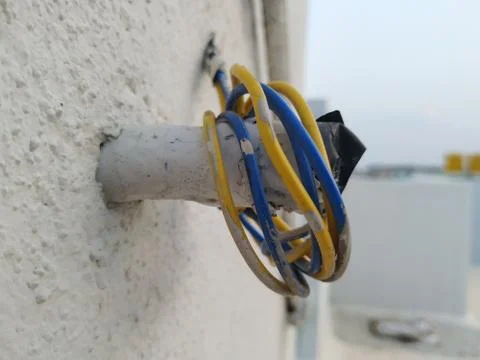 White Wall Fixed Small Plastic Pipe and Remaining Used Electrical Wires round Stock Photos