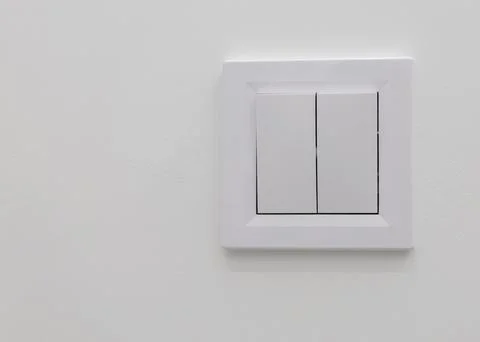A white wall inside a room with a light switch. Turn off the lights, house, copy Stock Photos
