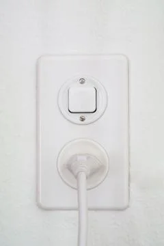 White wall mounted electricity plug and light switch close up shot isolated Stock Photos