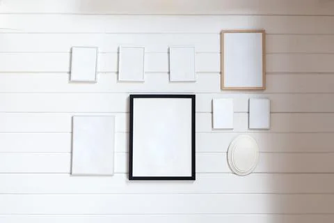White wall with multiple empty picture frames arranged in geometric pattern Foto stock