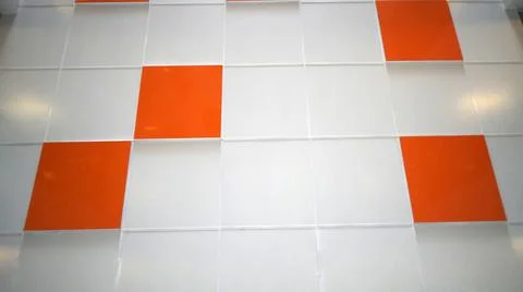 A white wall with an orange tile. Selective focus Stock Photos