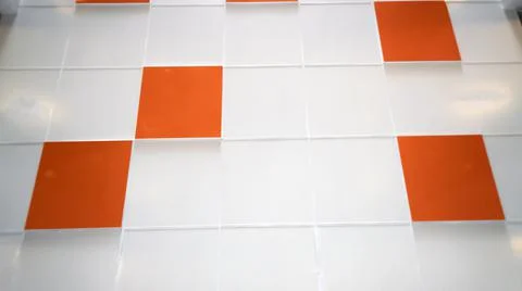 A white wall with an orange tile. Selective focus Stock Photos