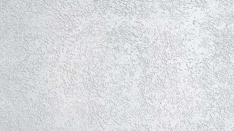 A white wall with a rough texture. The wall is covered in small white dots. T Stock-Fotos