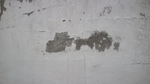 White wall surface with peeling paint showing grungy texture and aged crack.. Stock Photos
