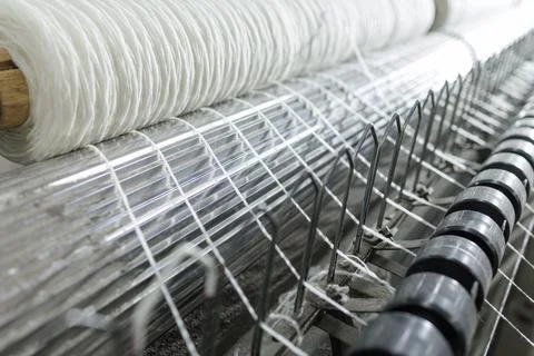 White warp threads aligned on industrial weaving machinery Stock Photos