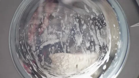 White washing machine washes dirty colorful clothes. Washing clothing in Video stock 205928402