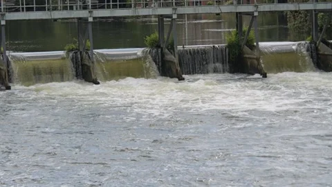 White water bubbles over the giant weir gantries on the Thames River alongs.. Stock Footage 316839378